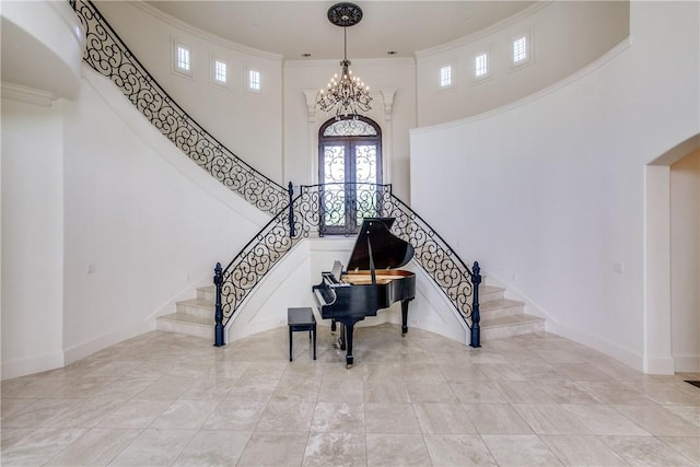 stairs featuring a towering ceiling, baseboards, and ornamental molding