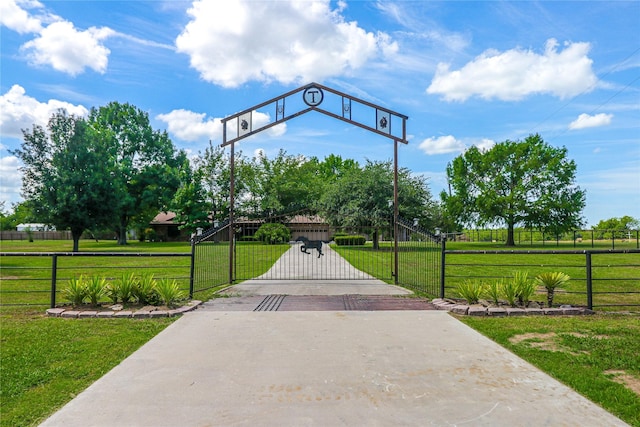 view of property's community featuring a lawn, a fenced front yard, and a gate