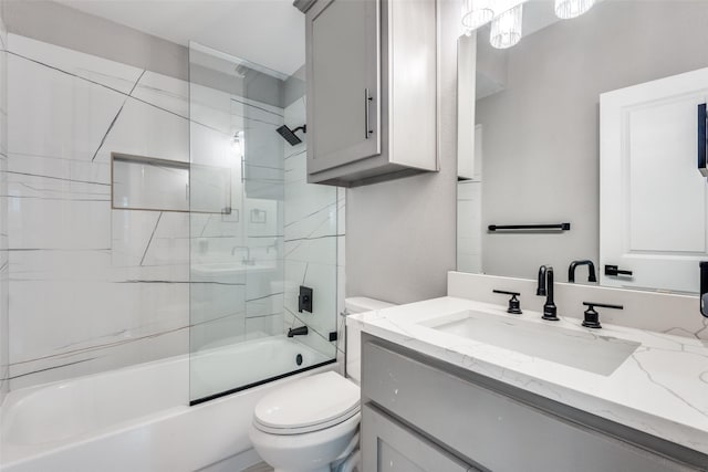 bathroom with toilet, combined bath / shower with glass door, and vanity