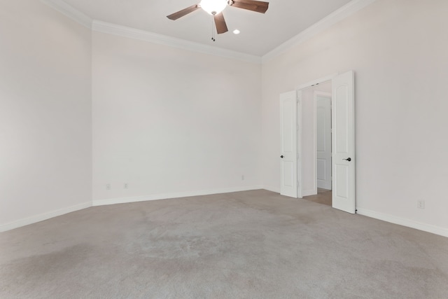 carpeted spare room featuring ceiling fan and crown molding