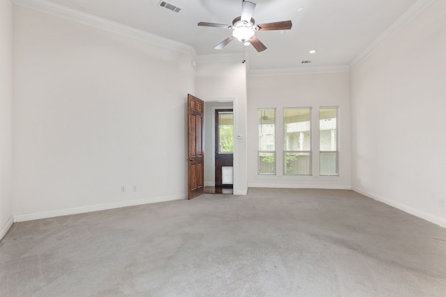 spare room featuring ceiling fan, crown molding, and light colored carpet