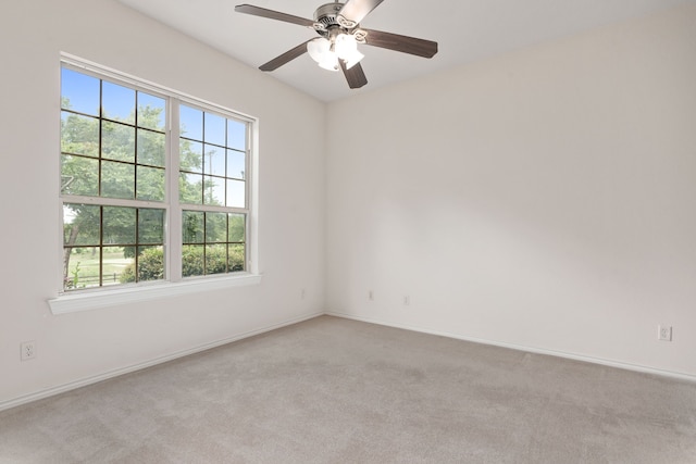 spare room with ceiling fan and light carpet