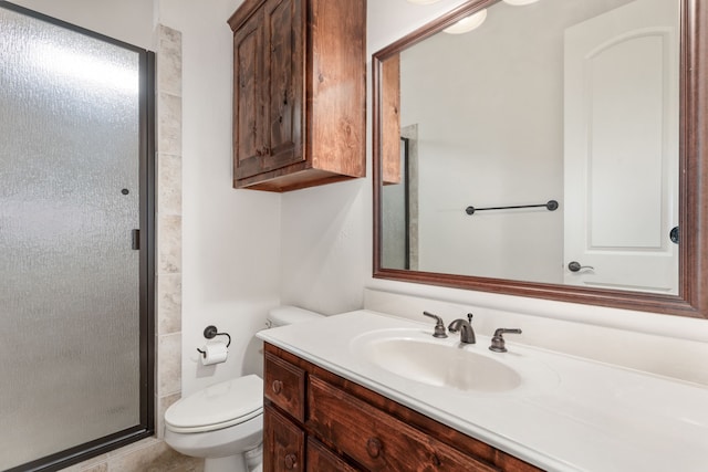 bathroom featuring toilet, a shower with door, and vanity