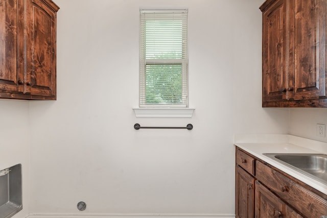 laundry area featuring sink and cabinets