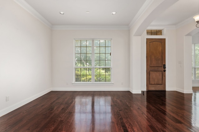 empty room with a healthy amount of sunlight, ornamental molding, and dark hardwood / wood-style floors