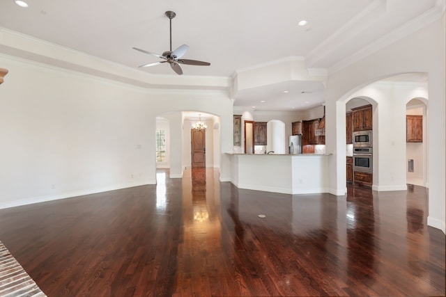 unfurnished living room with ceiling fan with notable chandelier, ornamental molding, and dark hardwood / wood-style floors