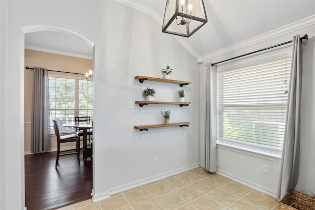 interior space with an inviting chandelier, lofted ceiling, light tile patterned floors, and ornamental molding