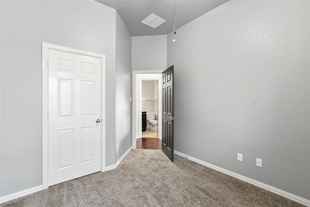 unfurnished bedroom with carpet flooring and lofted ceiling