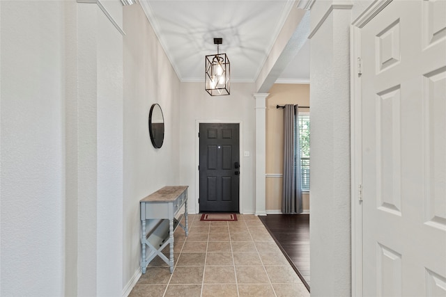 entryway with decorative columns, crown molding, and hardwood / wood-style floors