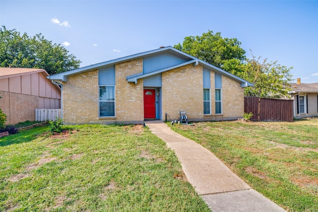 mid-century modern home with a front yard, brick siding, and fence