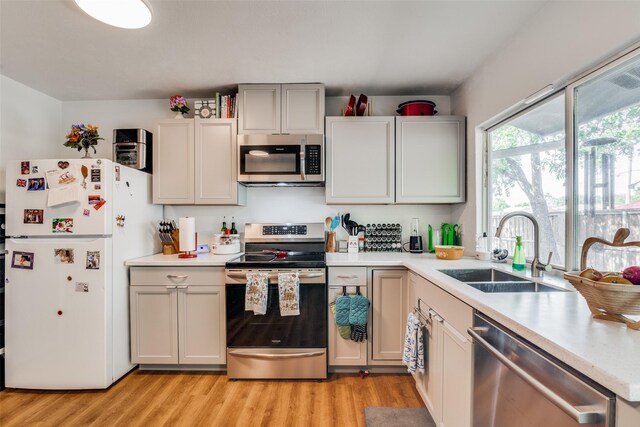 kitchen with sink, appliances with stainless steel finishes, and light wood-type flooring