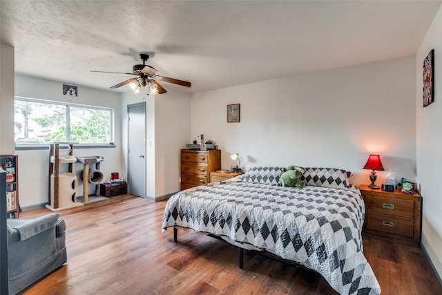 bedroom featuring a textured ceiling, ceiling fan, and hardwood / wood-style floors