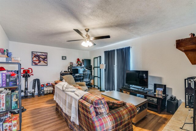 living room with a textured ceiling, light hardwood / wood-style flooring, and ceiling fan