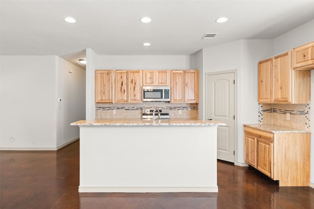 kitchen featuring light brown cabinetry, light stone counters, and decorative backsplash