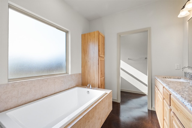 bathroom featuring tiled bath and vanity