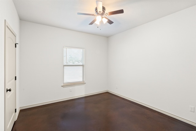 spare room with ceiling fan and concrete floors