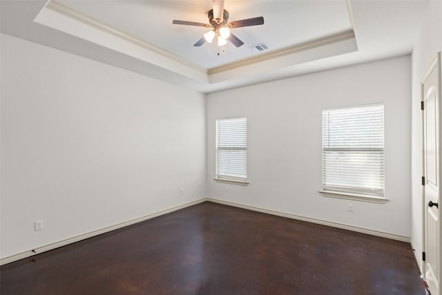 empty room featuring crown molding, a raised ceiling, plenty of natural light, and ceiling fan