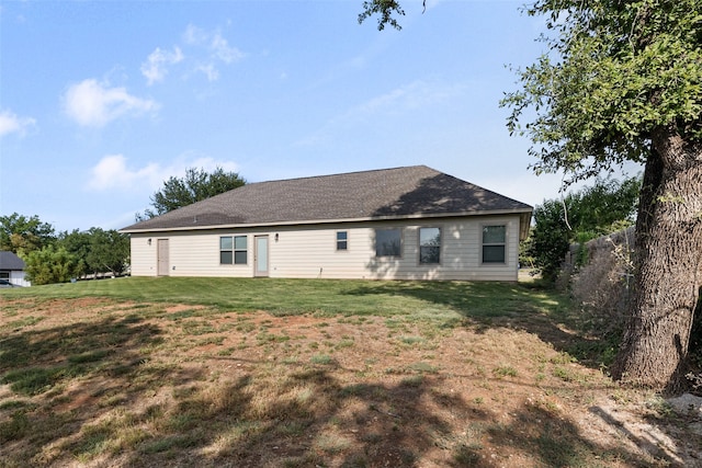 rear view of house featuring a lawn