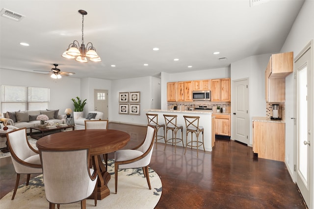 dining space featuring ceiling fan with notable chandelier