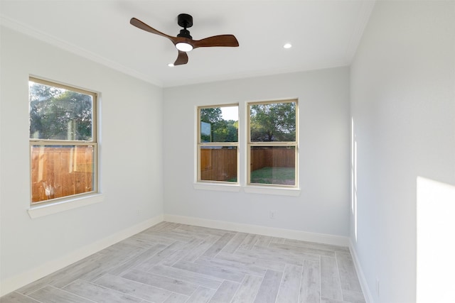 empty room featuring ceiling fan, light parquet floors, ornamental molding, and a healthy amount of sunlight