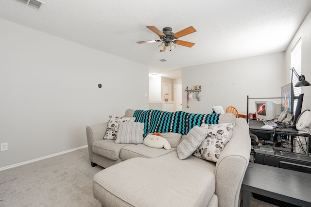 carpeted living room featuring a textured ceiling and ceiling fan