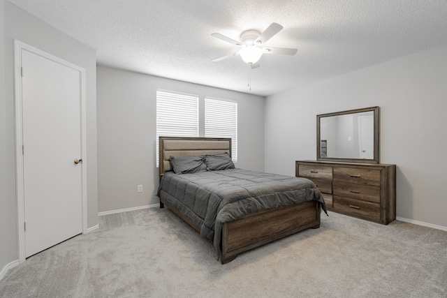 carpeted bedroom featuring a textured ceiling and ceiling fan