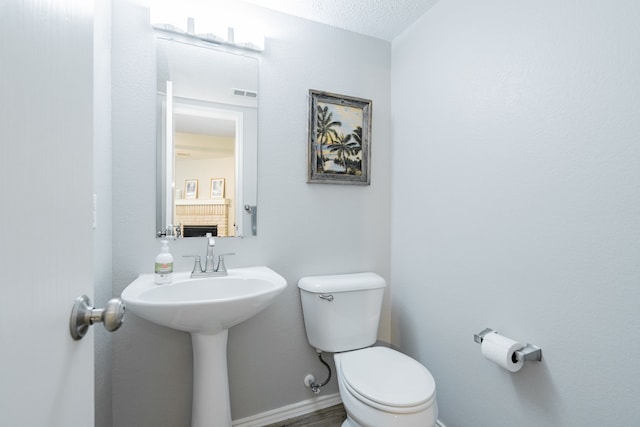 bathroom with toilet and a textured ceiling