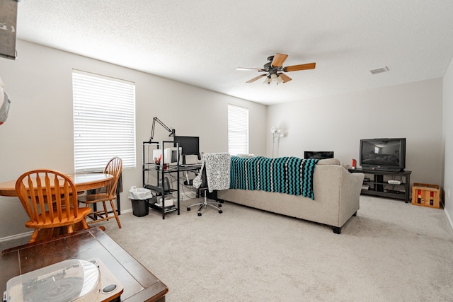 living room with carpet, a textured ceiling, and ceiling fan