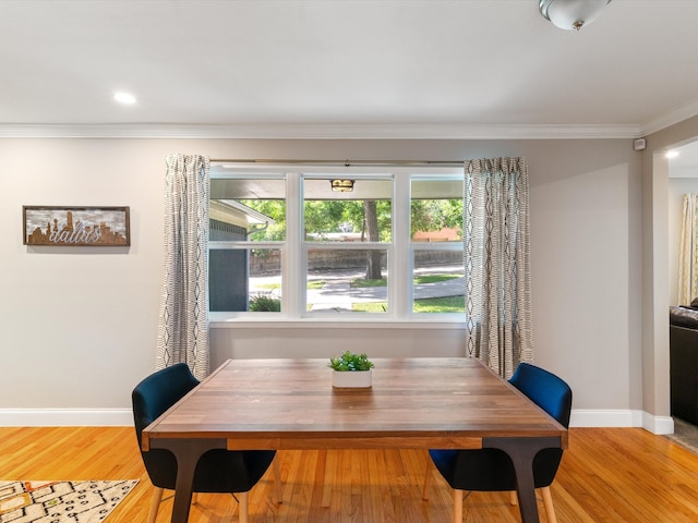 dining space featuring light hardwood / wood-style floors and ornamental molding