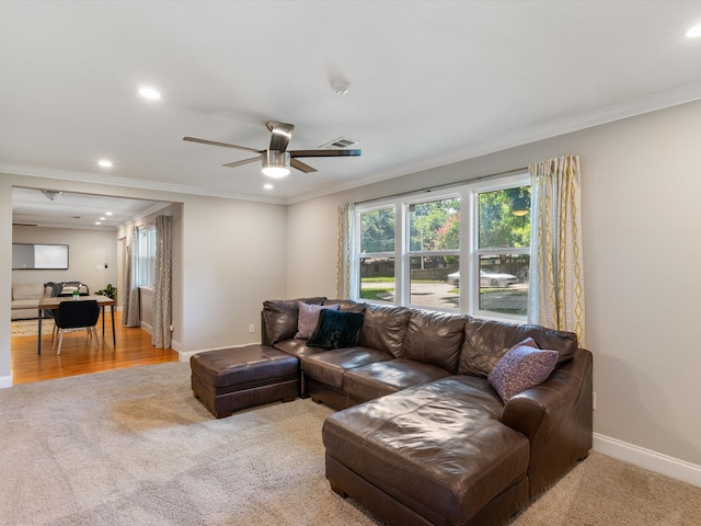 carpeted living room featuring crown molding and ceiling fan