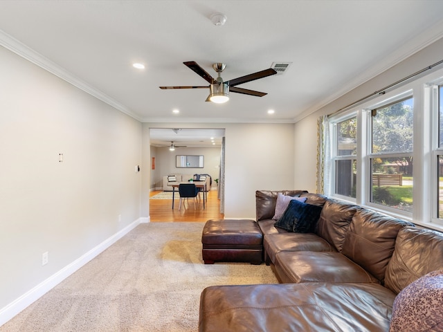 carpeted living room featuring ceiling fan and ornamental molding