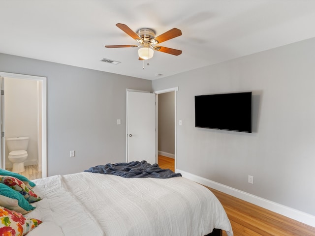 bedroom with light hardwood / wood-style floors, ensuite bath, and ceiling fan