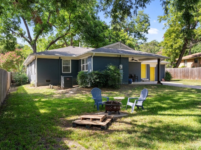 rear view of house with a patio, central air condition unit, a yard, and an outdoor fire pit