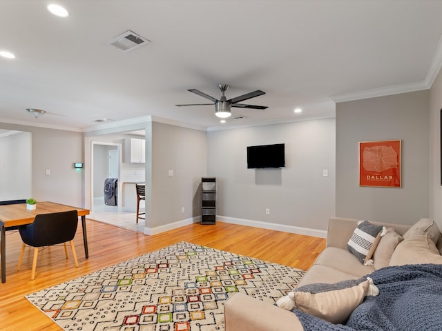 living room with ornamental molding, ceiling fan, and light wood-type flooring