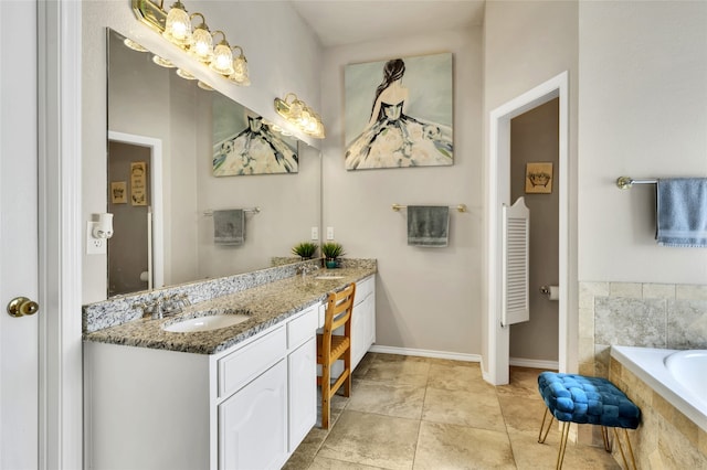 bathroom with tiled bath, tile patterned flooring, and vanity