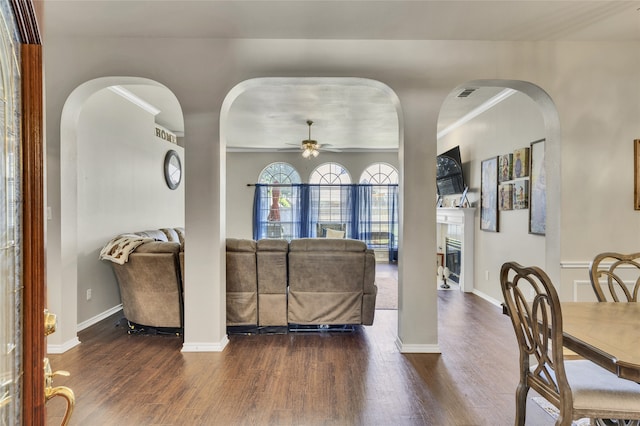 living room with ceiling fan, dark hardwood / wood-style floors, and ornamental molding