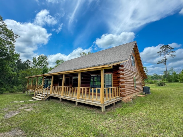 log home featuring a wooden deck and a front lawn