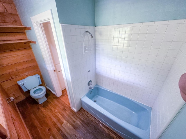 bathroom featuring tiled shower / bath combo, toilet, and hardwood / wood-style flooring