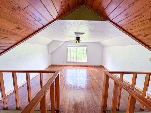 additional living space featuring a textured ceiling, ceiling fan, wooden ceiling, hardwood / wood-style flooring, and vaulted ceiling