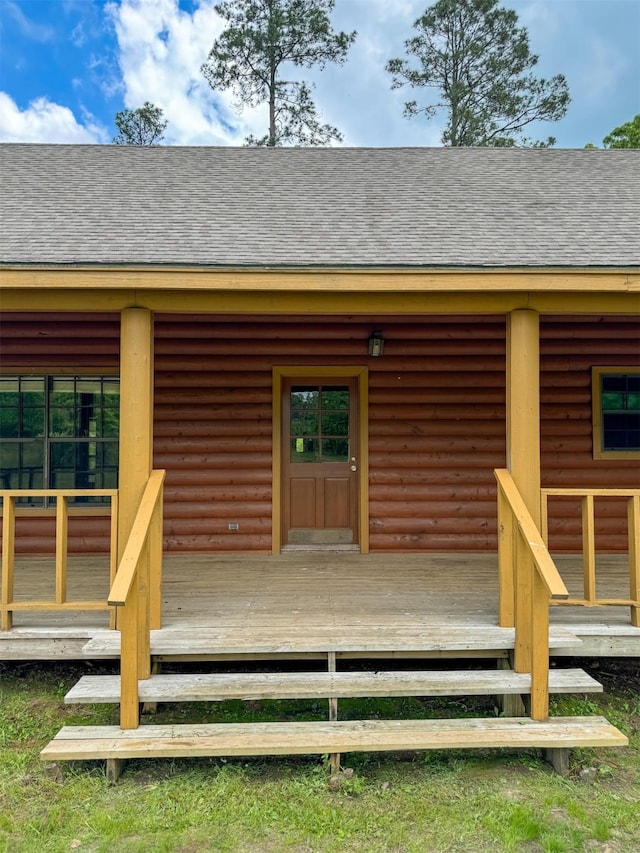 view of exterior entry featuring a wooden deck