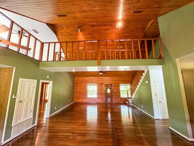 unfurnished living room with high vaulted ceiling, wood walls, wooden ceiling, and hardwood / wood-style flooring