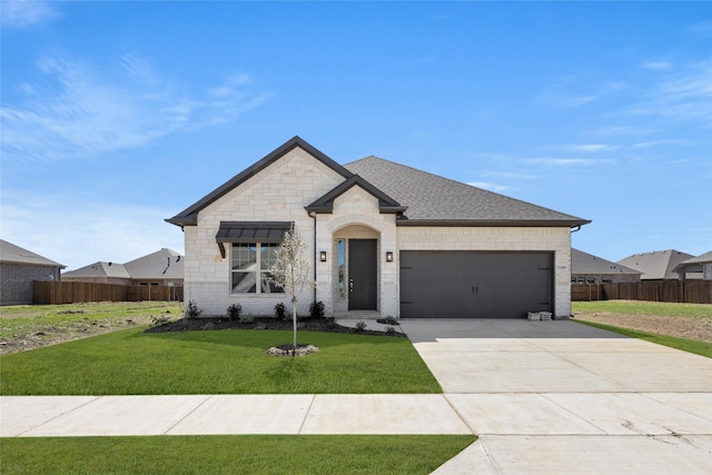 french country home featuring fence, concrete driveway, a front yard, a garage, and brick siding