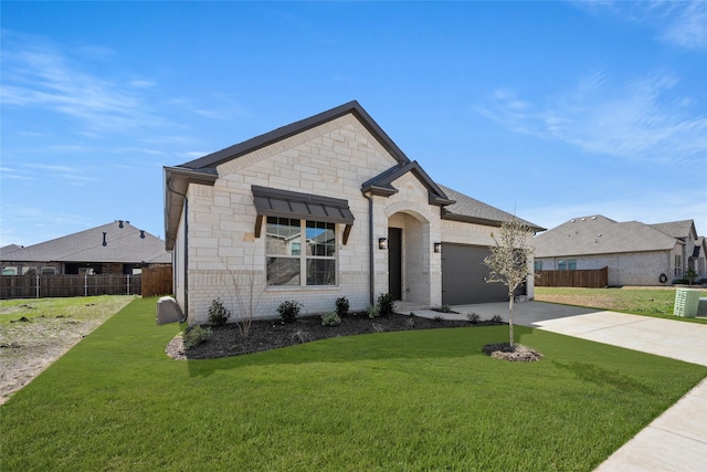 french country style house featuring a front lawn, driveway, fence, a garage, and brick siding