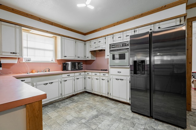 kitchen featuring white cabinetry, stainless steel appliances, a textured ceiling, ornamental molding, and sink