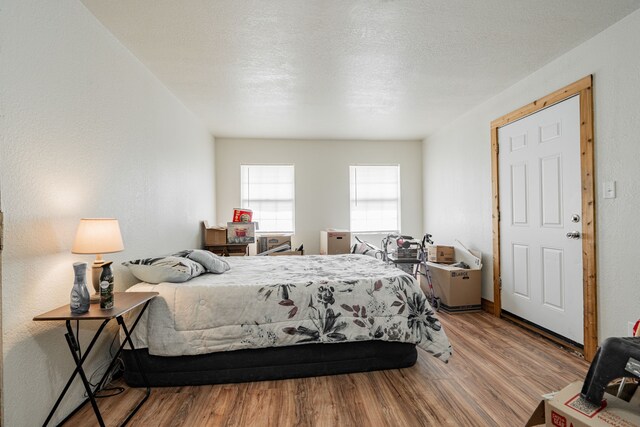 bedroom with wood-type flooring and a textured ceiling