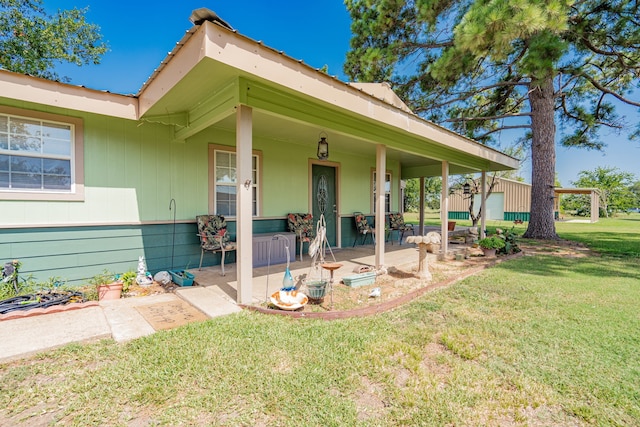 entrance to property featuring a porch and a lawn