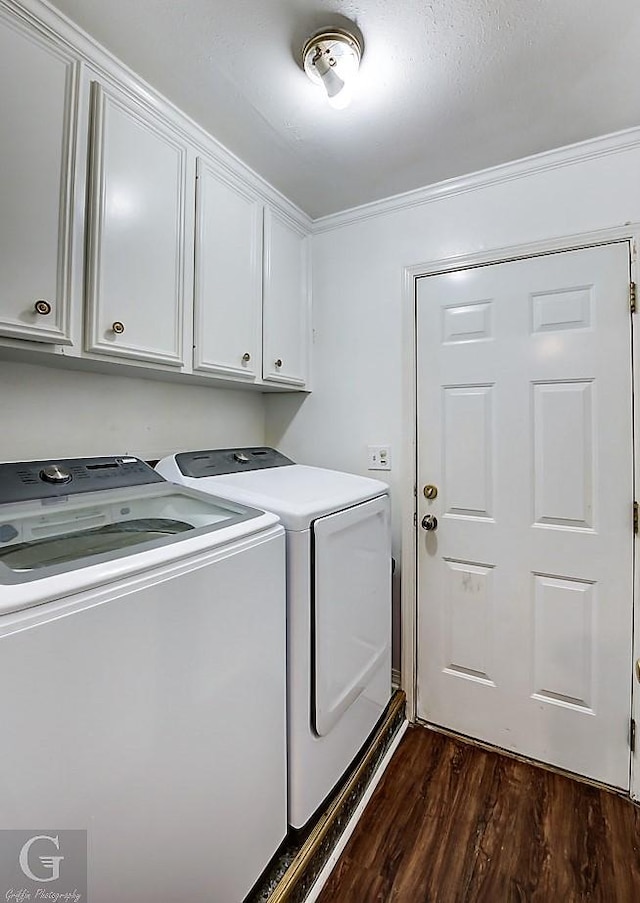 washroom with cabinets, ornamental molding, dark hardwood / wood-style floors, and washer and clothes dryer