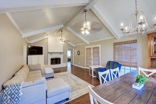 living room featuring a large fireplace, ceiling fan with notable chandelier, ornamental molding, lofted ceiling with beams, and dark wood-type flooring