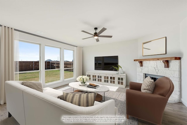 living room with ceiling fan, a fireplace, and wood-type flooring