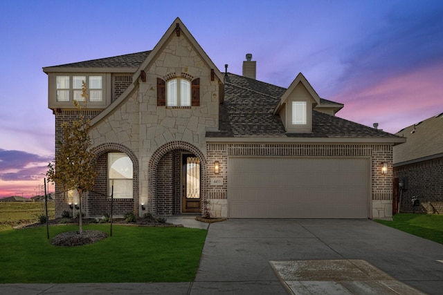 view of front of house with a garage and a yard